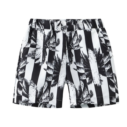 Colourful printed beach shorts with elastic waistband showing tropical patterns including coconut trees and pineapples
