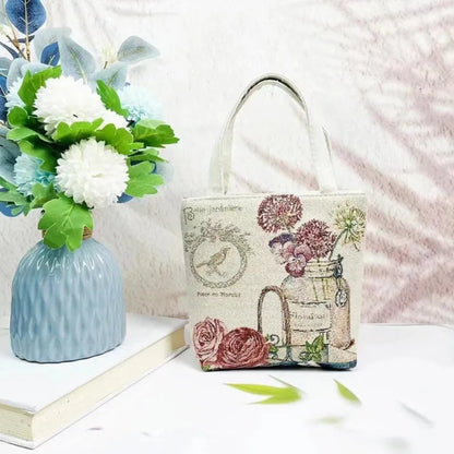 Colourful embroidered canvas shoulder bag with gold wire handles shown in small, medium, and large sizes.