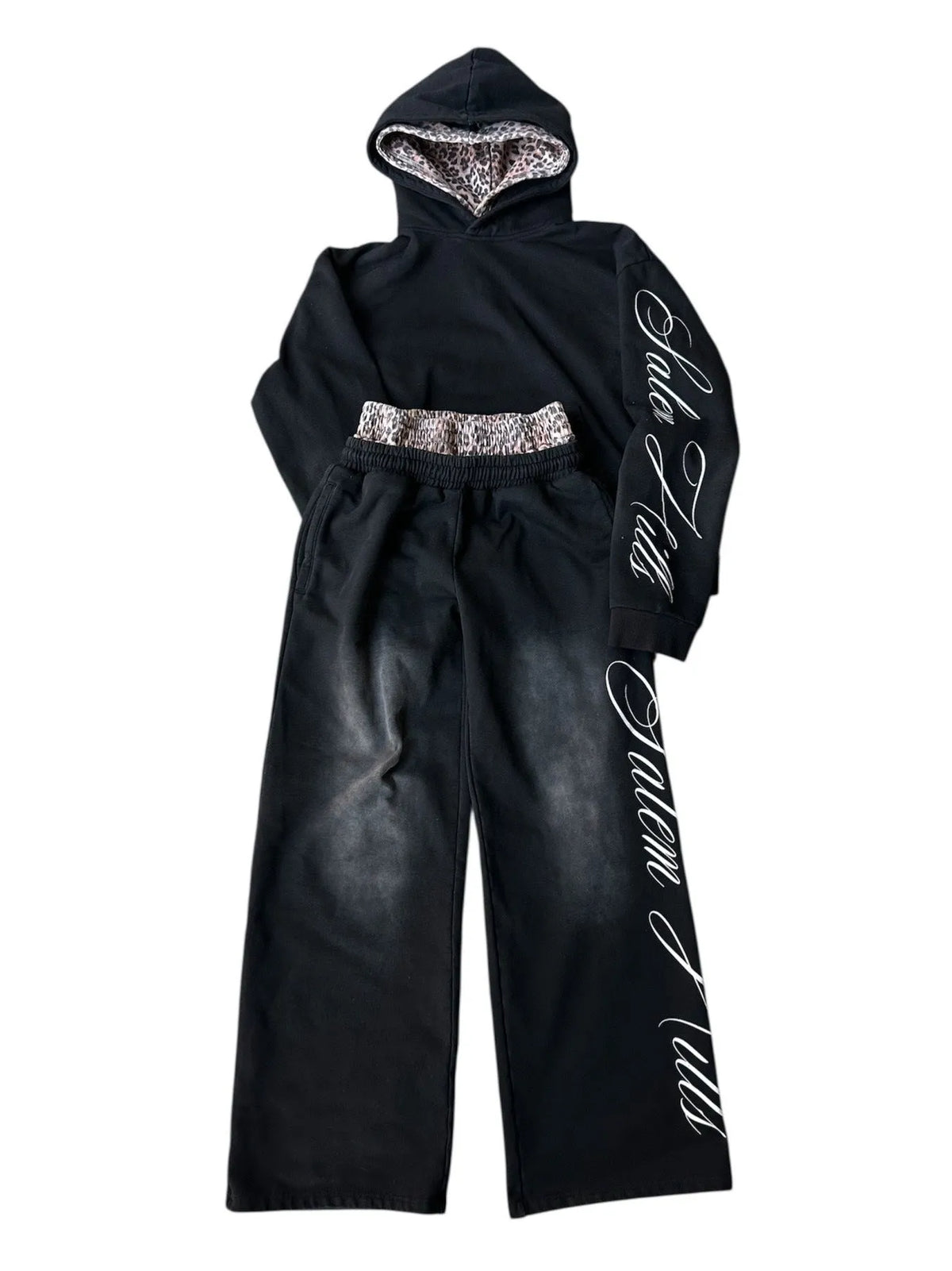 Man wearing a black punk print hoodie and matching trousers, a casual lounge suit set.