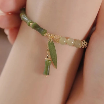 Chinese style glass bead bracelet with bamboo joint design on wrist.
