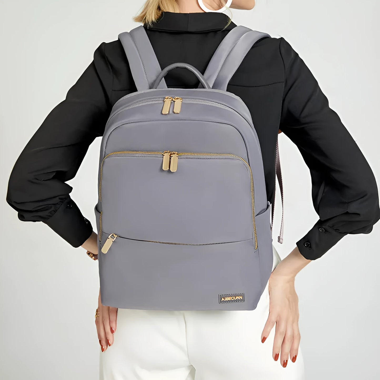 Oxford cloth women's backpack in black or purplish grey showing large capacity and padded straps