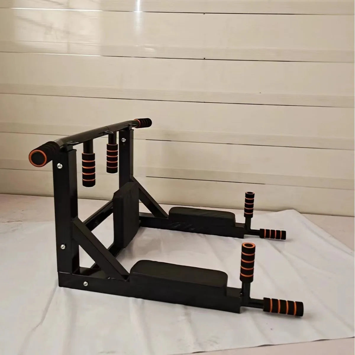 Black wall-mounted fitness station with sandbag rack and parallel bars measuring 77cm wide by 47cm high