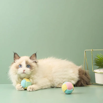 Handmade blue and green cotton plush ball cat toy, 5cm in diameter, on a wooden floor.