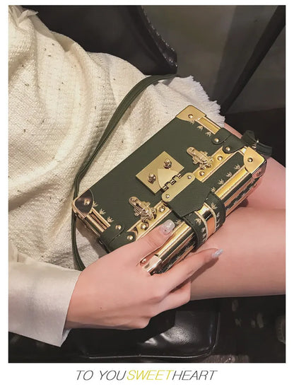 Women's hard flap shoulder bag in black or green with single adjustable strap and rivet decoration