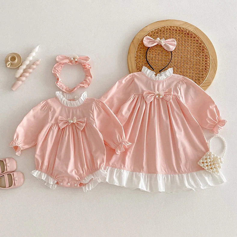 Girl wearing peach branch climbing colour triangle jumpsuit with princess dress styling and matching headband