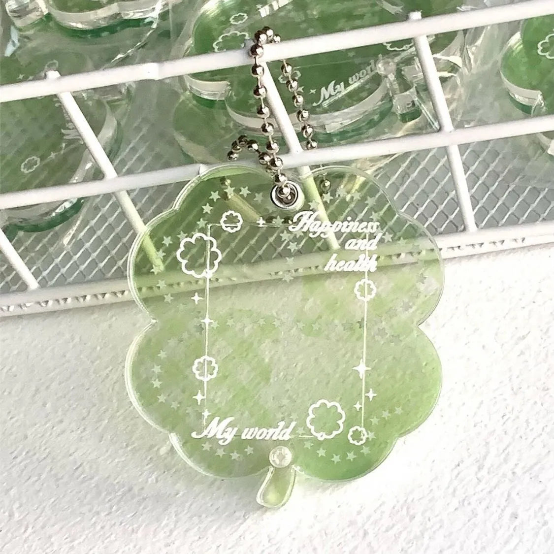 Blue, green, and mint green four-leaf clover acrylic pendant keychain on a metal ring.
