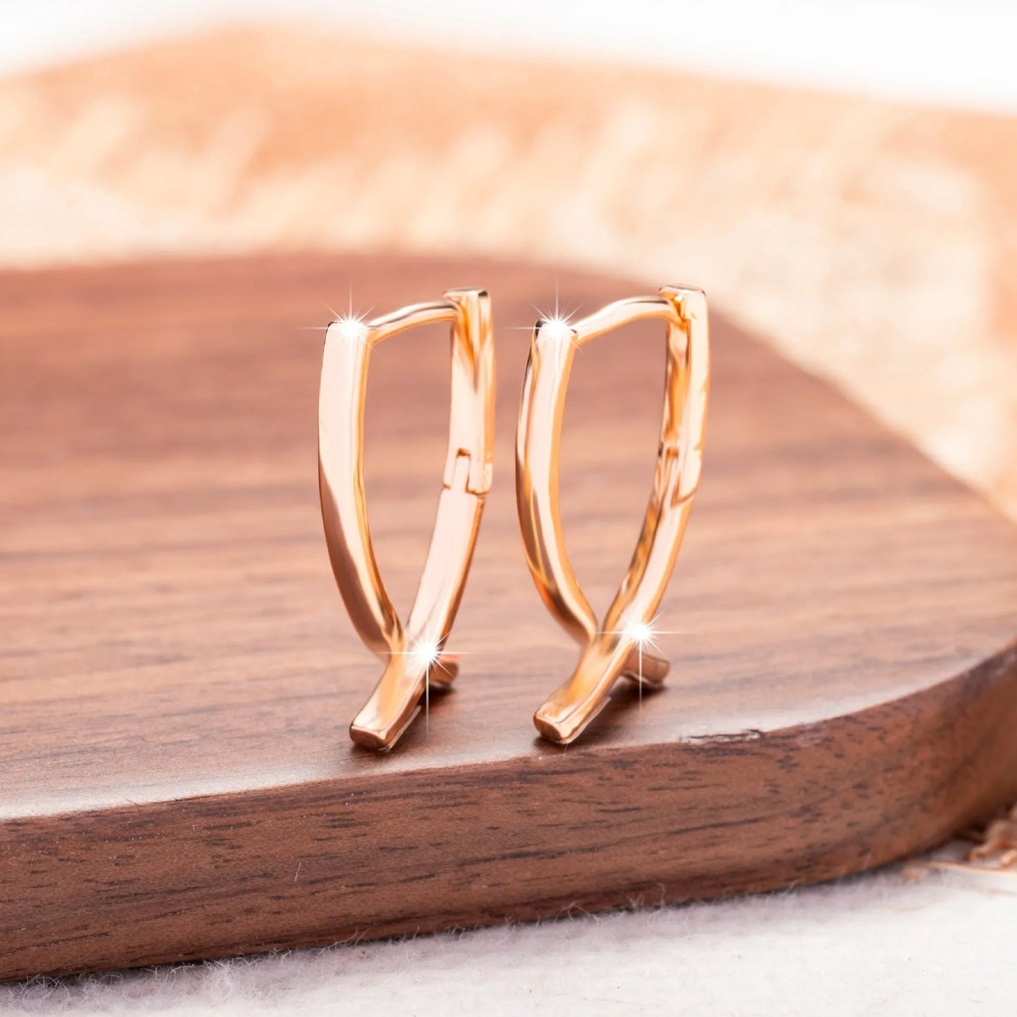 Cross-shaped copper earrings with rose gold finish, showing dimensions and post closure