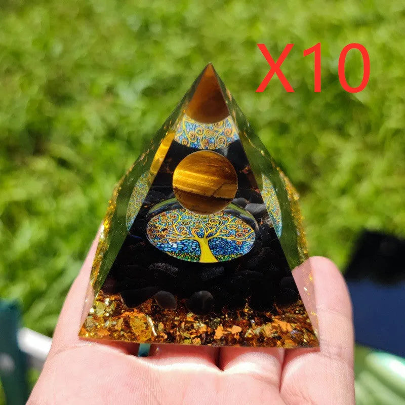 A small 6cm clear epoxy resin pyramid ornament containing pieces of natural crystal gravel on a flat surface.