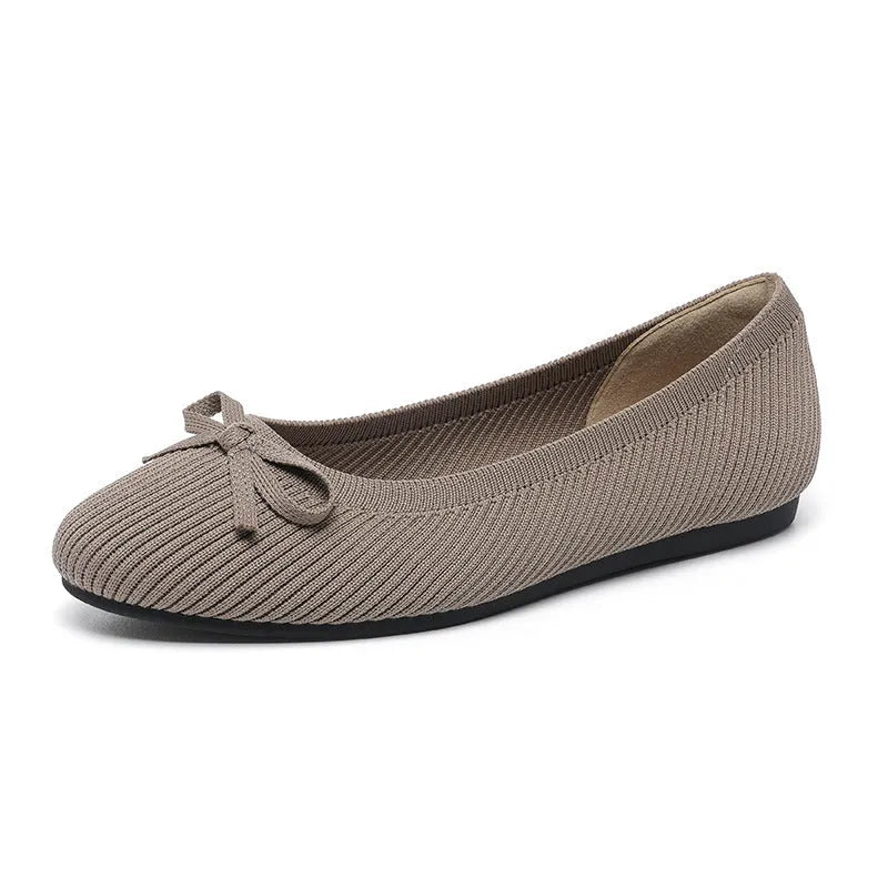 Women's black fabric flat pumps with a bow detail on the round toe, shown on a white background.