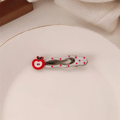 Red plastic hair clip with a 3D love heart and dots on a willow leaf-shaped base.