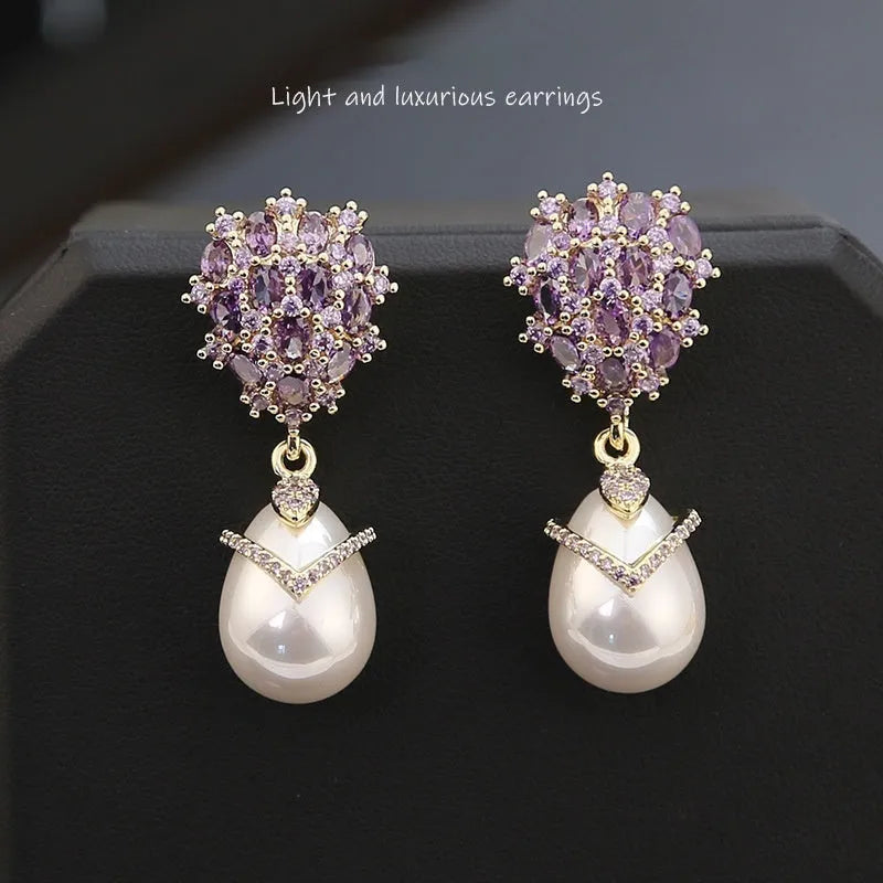 Women's drop-shaped freshwater pearl earrings with zircon inlay on 18K gold-plated settings.