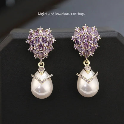 Women's drop-shaped freshwater pearl earrings with zircon inlay on 18K gold-plated settings.