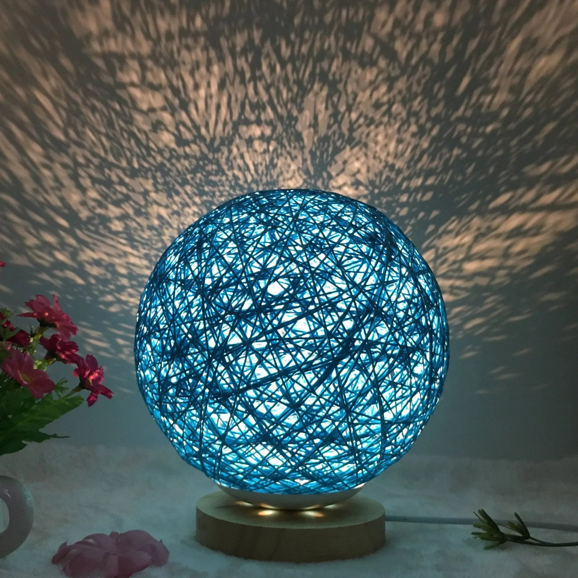 Spherical hand-knitted rattan table lamp with remote control on a wooden desk