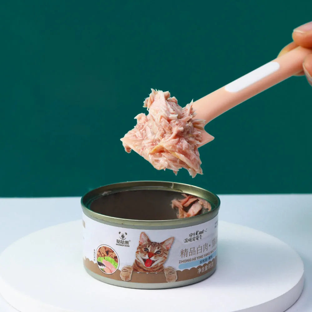 Green long-handled plastic spoon for scooping pet food from a can.