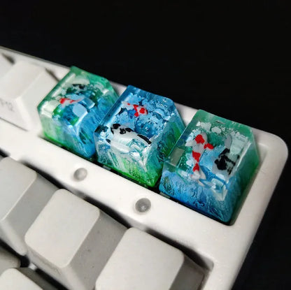 Close-up of a custom resin keycap featuring a detailed blue and orange koi fish scene, designed for Cherry MX mechanical keyboards.