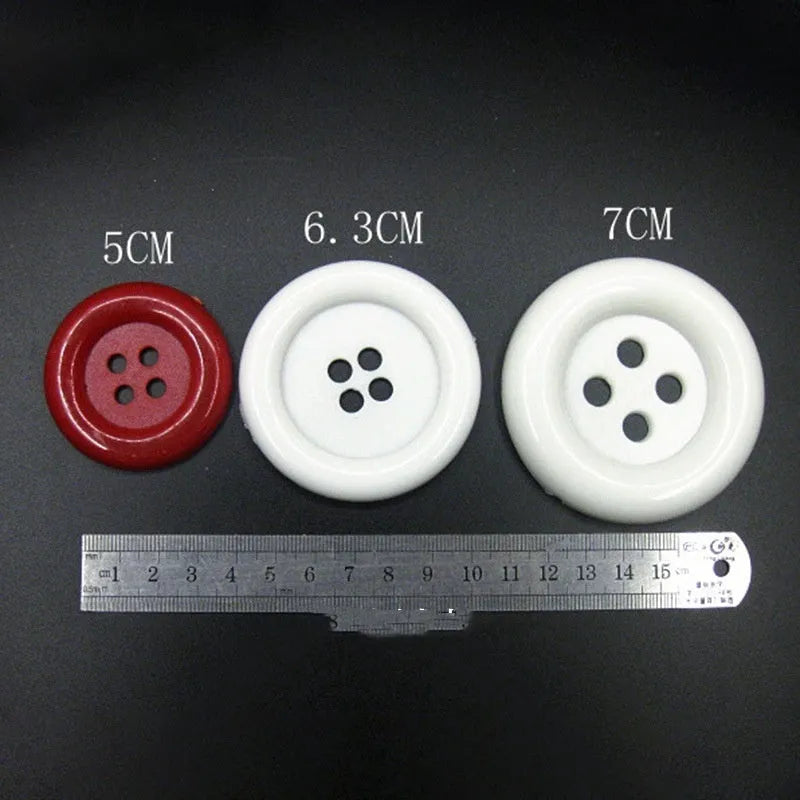 Assorted oversized round plastic buttons in various colours showing four-hole sew-through design.