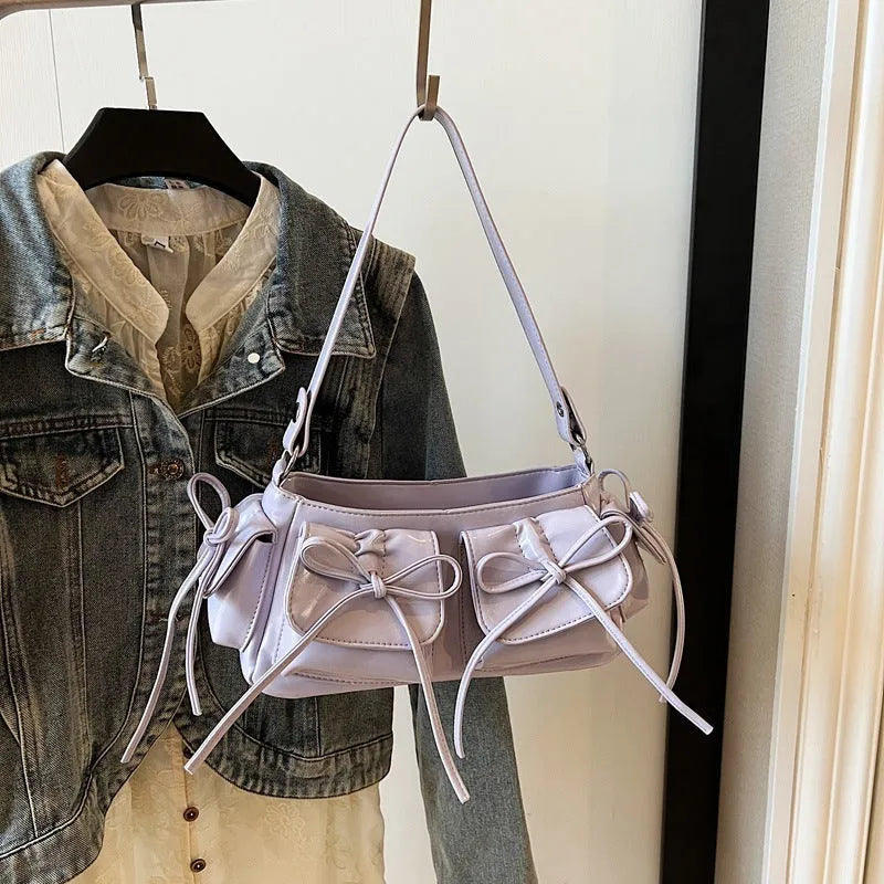 Women's tassel bow shoulder bag in pleated design with multiple pockets, shown in a selected colour.
