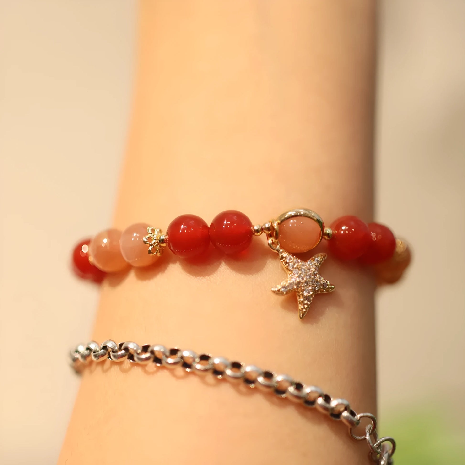 Women's handmade red agate and sunstone bracelet with ethnic charms