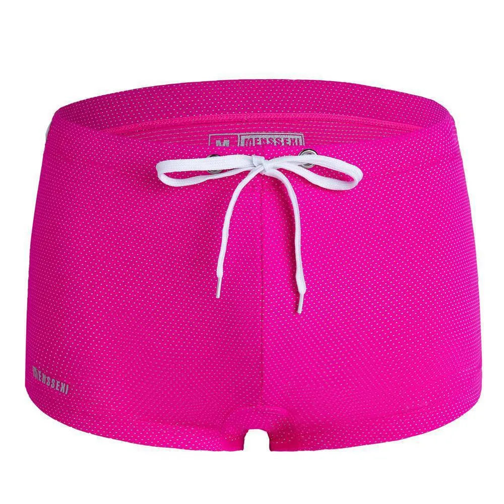 Men's low waist boxer style swimming trunks in nylon, available in multiple solid colours.