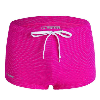 Men's low waist boxer style swimming trunks in nylon, available in multiple solid colours.
