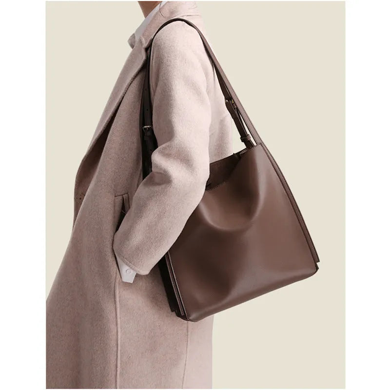 Brown genuine leather women's bucket bag with double shoulder straps showing organisational compartments