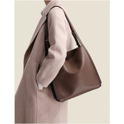 Brown genuine leather women's bucket bag with double shoulder straps showing organisational compartments