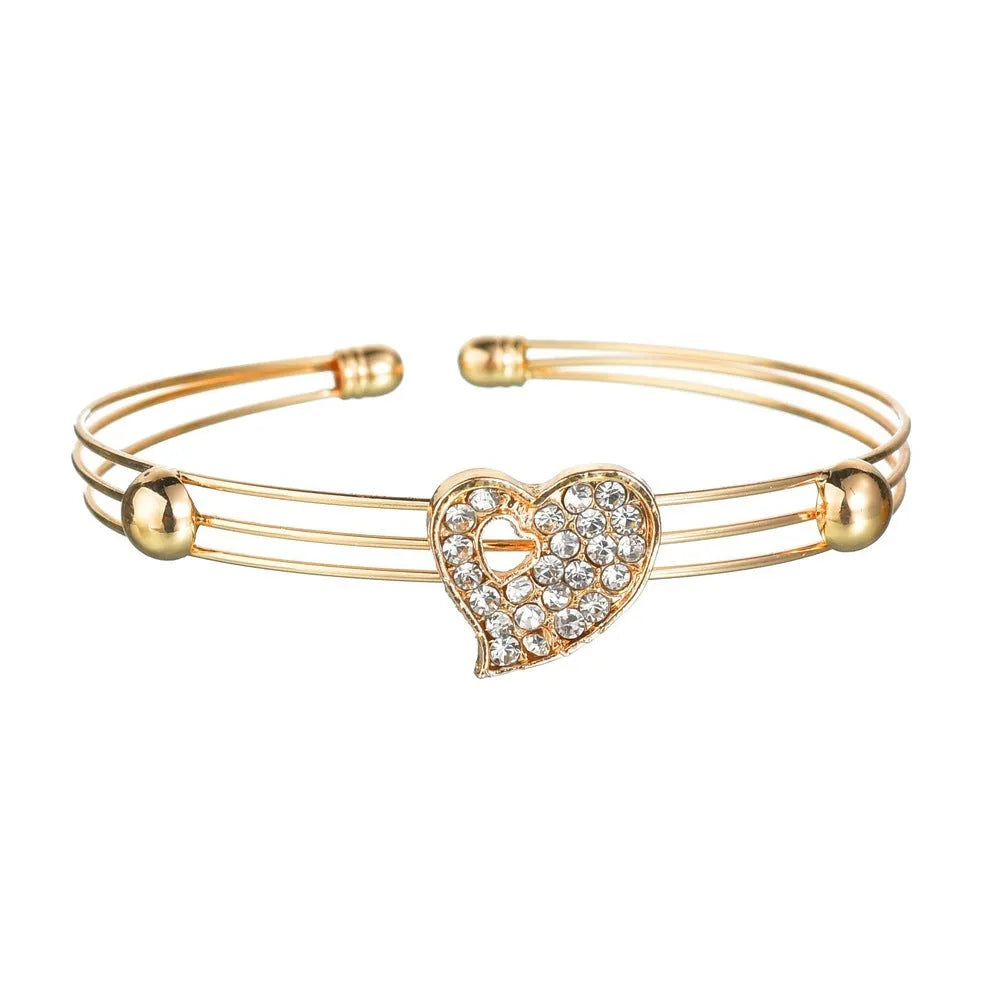 Gold-coloured women's love jewellery set with earrings, pendant and bracelet featuring bell patterns