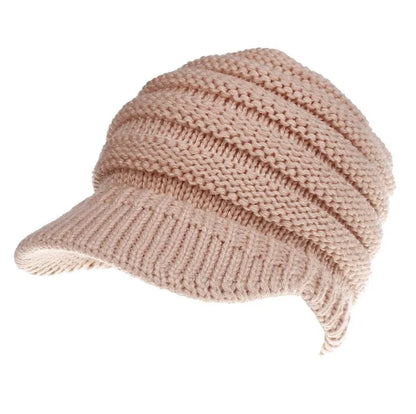 Woman wearing a light grey knitted ponytail beanie with her ponytail pulled through the hole in the back.