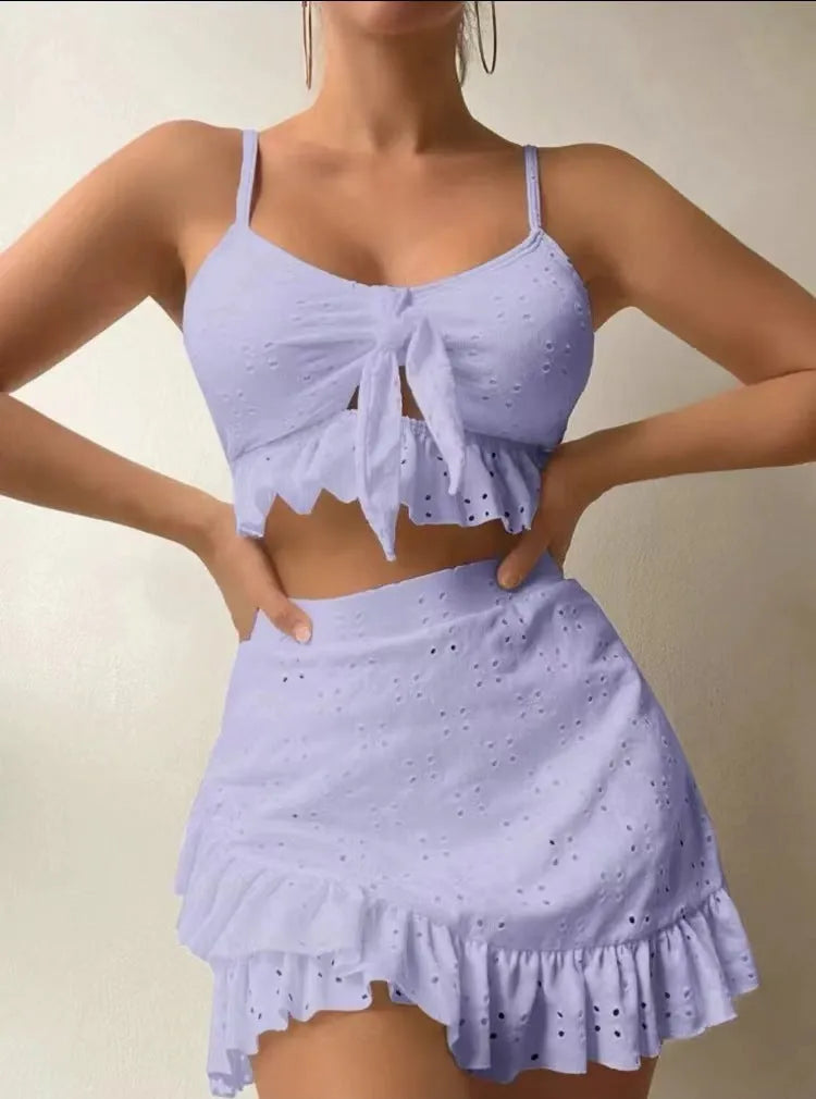 Women's white split hip skirt three-piece bikini swimsuit set on a mannequin.