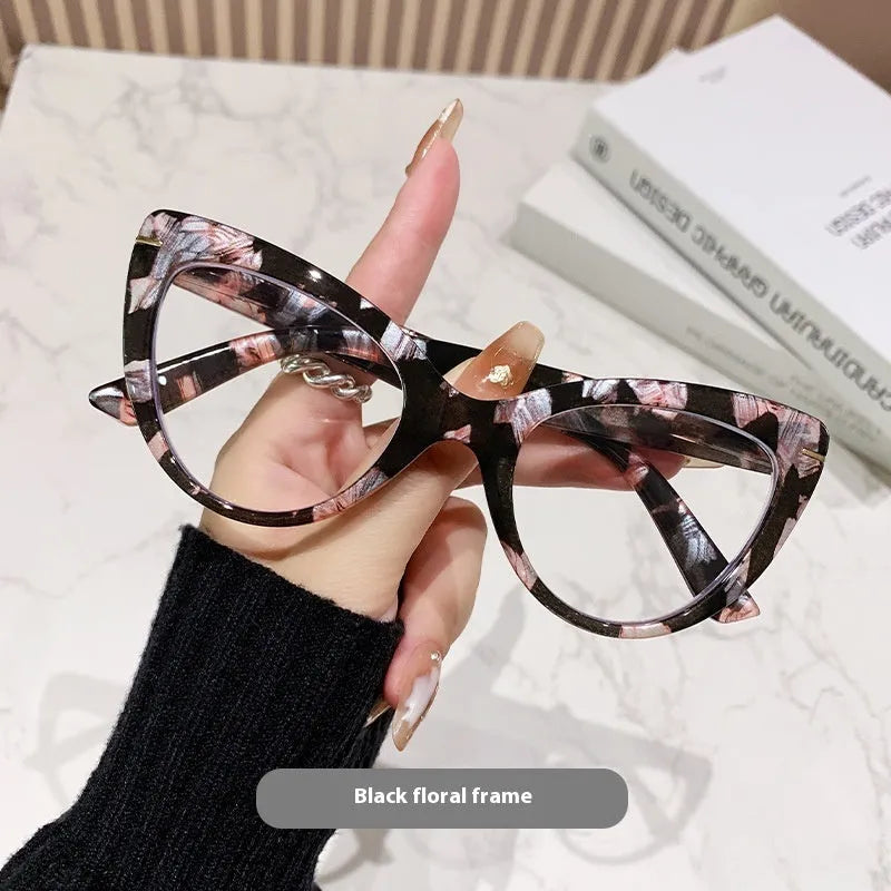 Women's black cat's eye reading glasses with gold dragon and phoenix decorations on the temples.