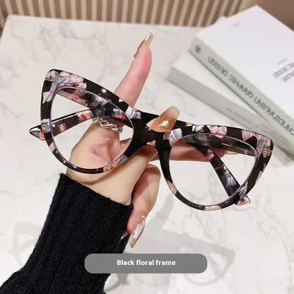 Women's black cat's eye reading glasses with gold dragon and phoenix decorations on the temples.