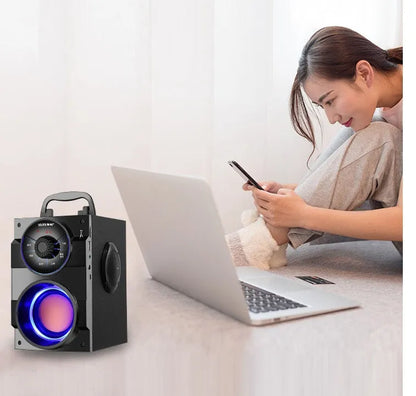 Black portable mini home audio system with built-in subwoofer, 3.5mm audio port, and USB charging cable