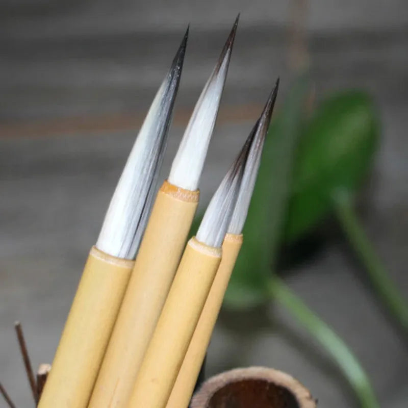 Four traditional Chinese calligraphy brushes with thin gold bodies and pine branch design
