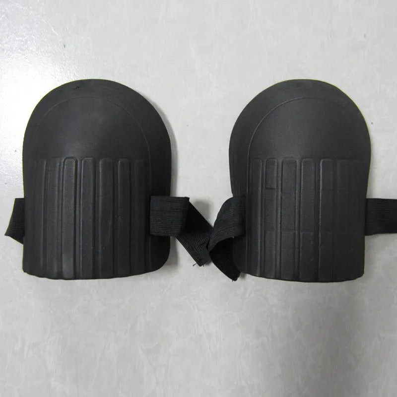A pair of rectangular EVA foam knee pads in army green colour, placed on a garden soil background.