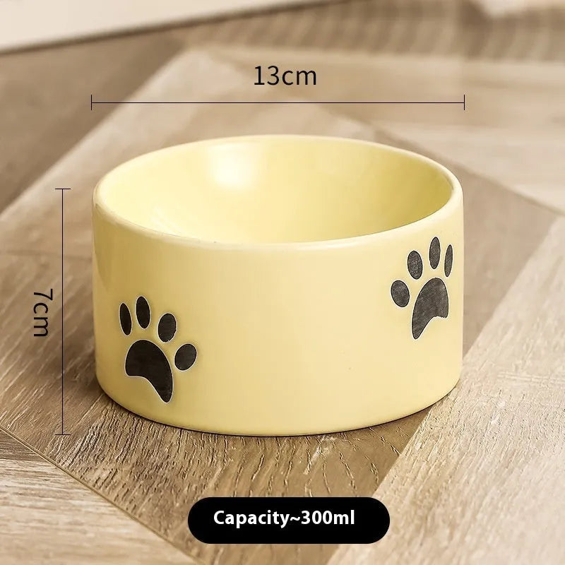 Ceramic cat bowl with high foot and cat's paw base in an oblique mouth design.