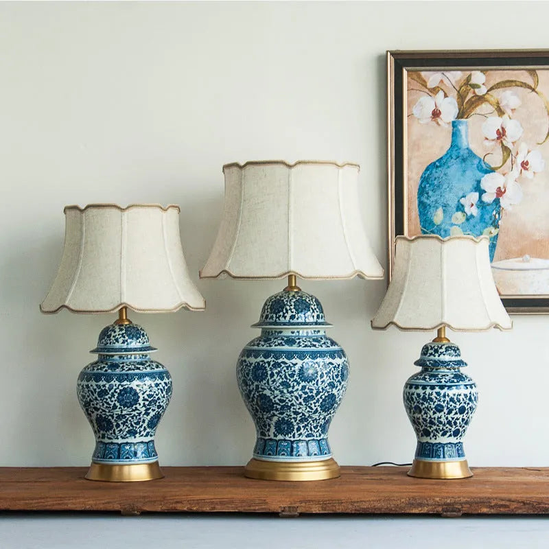 Traditional blue and white Chinese ceramic table lamp with a cloth shade on a bedside table.