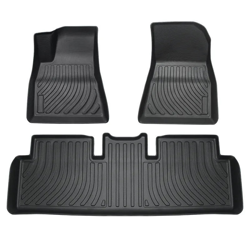 Black TPE rubber floor mats for Tesla Model 3, showing deep grooves and raised edges on driver's side.