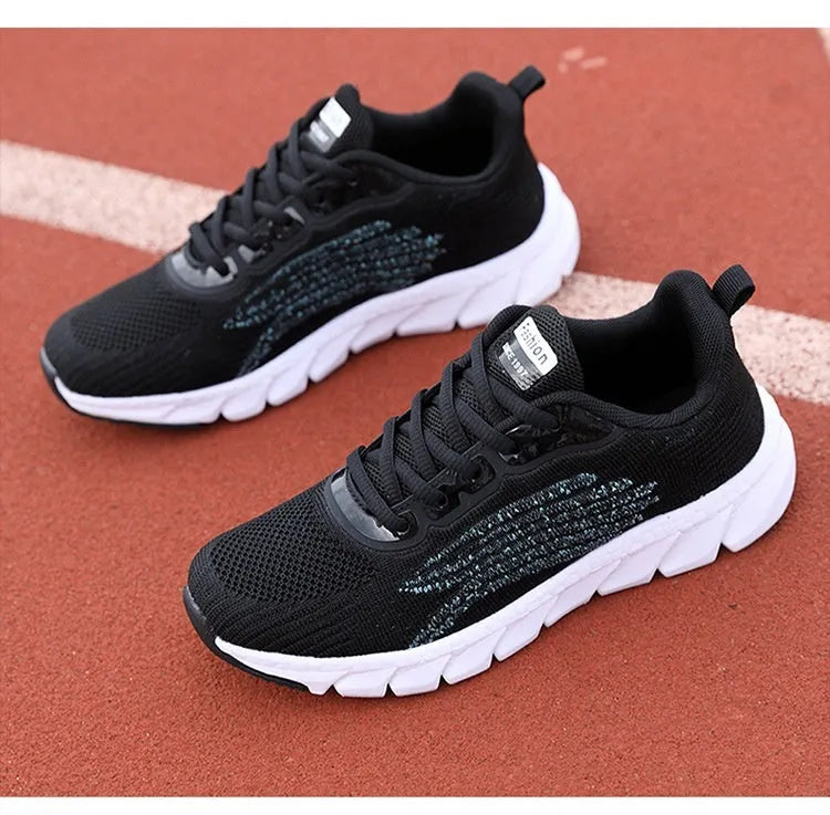 Women's black and white low-top running casual sneakers with MD sole and cross strap detail