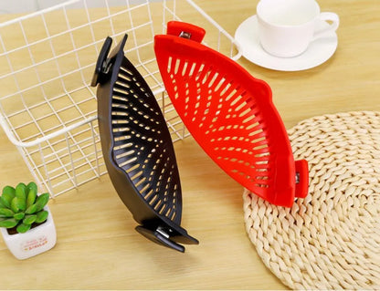 Silicone clip-on kitchen strainer with stainless steel frame attached to pot rim