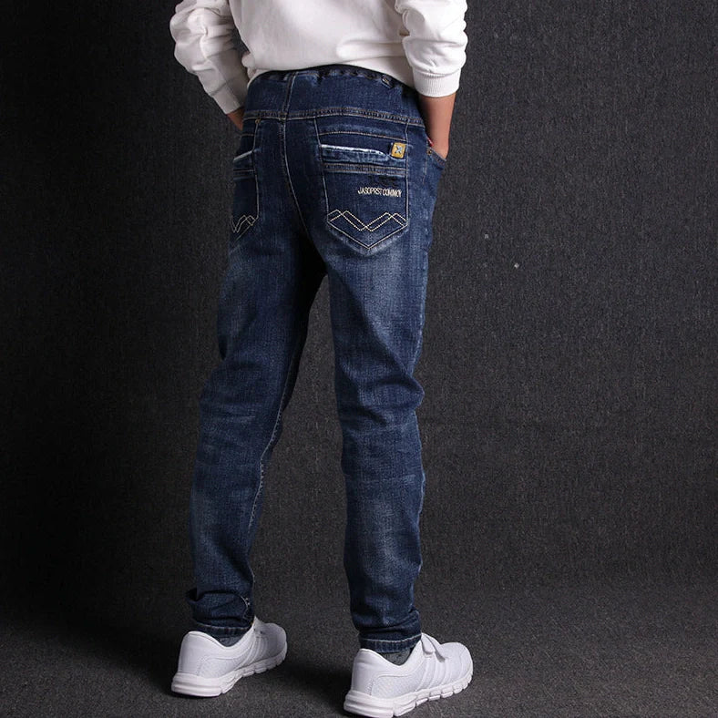 Boys' black micro-stretch cotton jeans showing 4-way flexibility and middle waist design