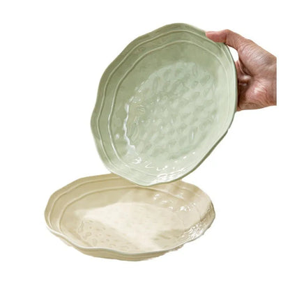 Boxed set of seven solid-colour ceramic plates and bowls on a table.