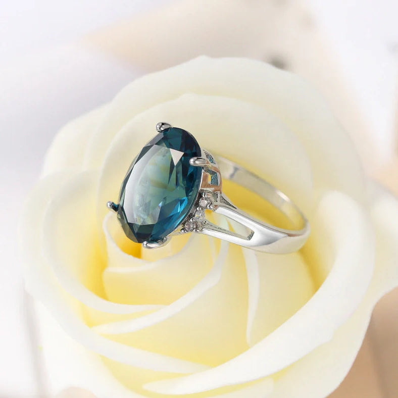 Geometric ellipse ring with electroplated blue black finish on copper, showing distinctive angles and curves