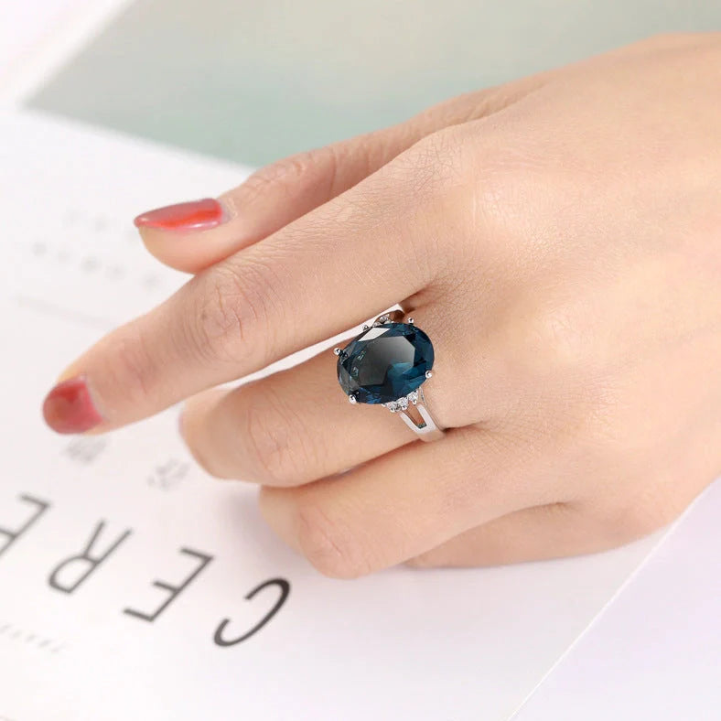 Geometric ellipse ring with electroplated blue black finish on copper, showing distinctive angles and curves