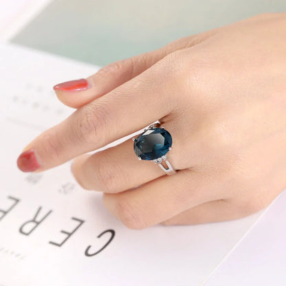 Geometric ellipse ring with electroplated blue black finish on copper, showing distinctive angles and curves