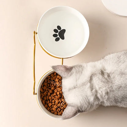 White ceramic pet bowl with cat paw design on a black iron frame raised feeder.