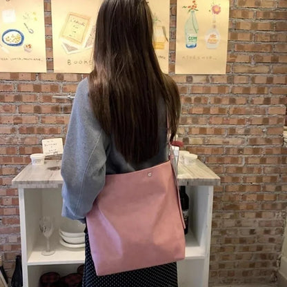 Pink corduroy one-shoulder bag showing its textured fabric and single strap.