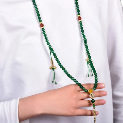 Close-up of a multi-strand green agate bracelet with natural stones on a wrist.