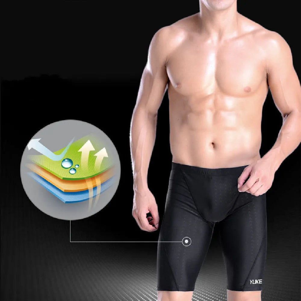Men's black swimming trunks, goggles, and cap set laid out with ear plugs and carry bag