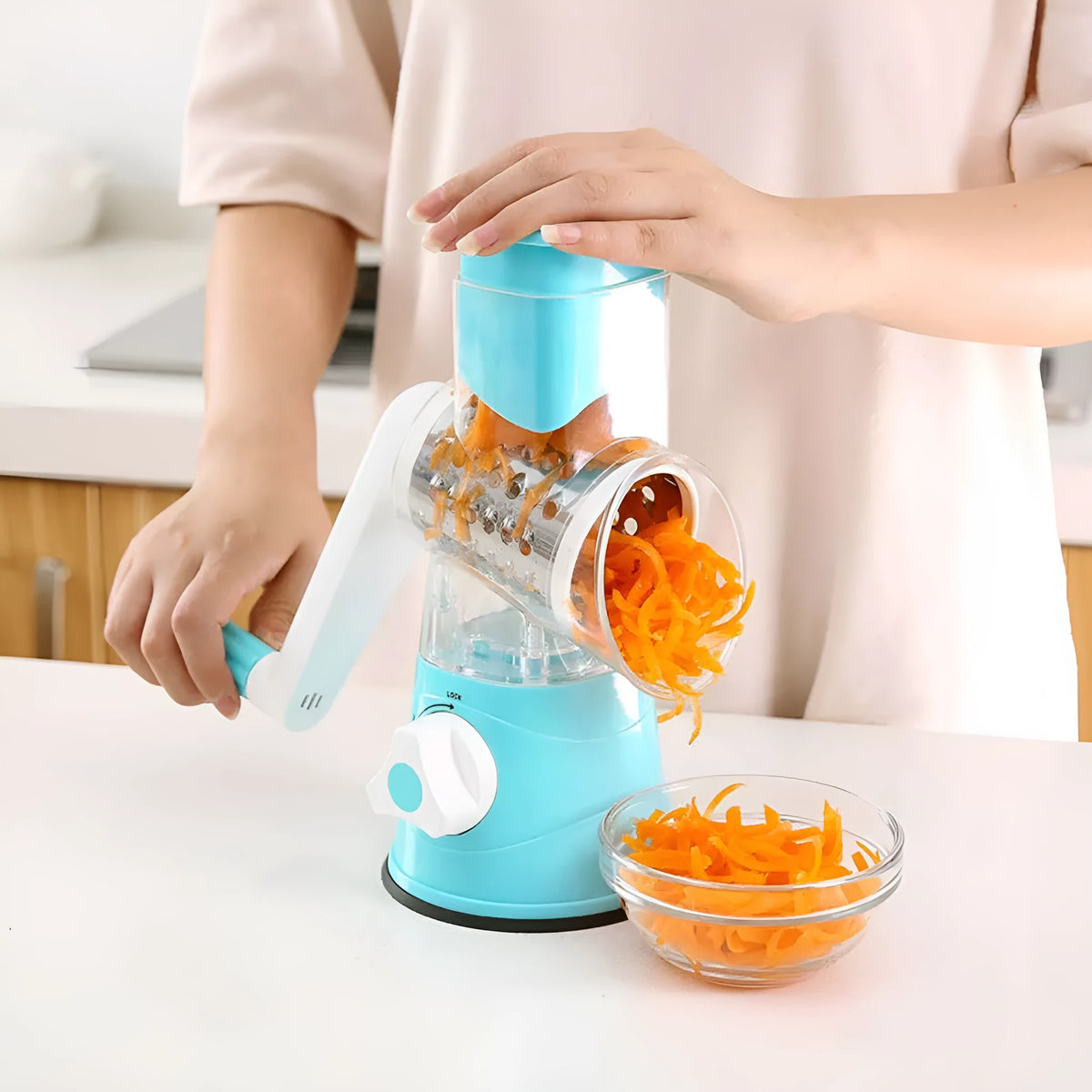 Hand drum rotary grater with handle and food-grade stainless steel blades, shown in Blue, Green or Red for cutting carrots and potatoes.