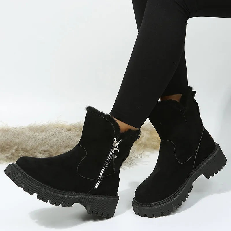 Women's black high top snow boots with a faux suede upper and side zipper on a white background.